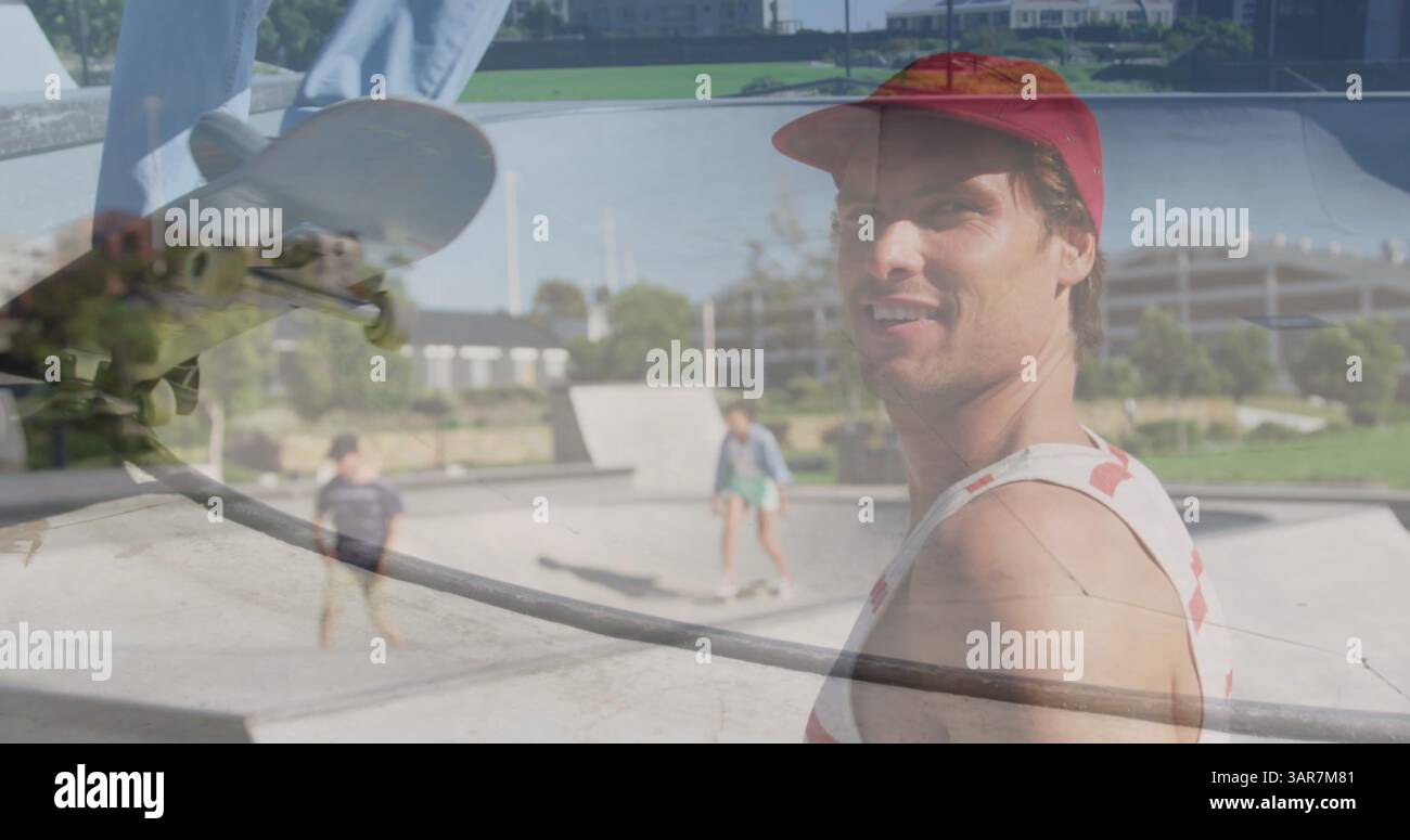 Immagine di un uomo caucasico skateboard su un uomo caucasico sorridente nello skate Park Foto Stock