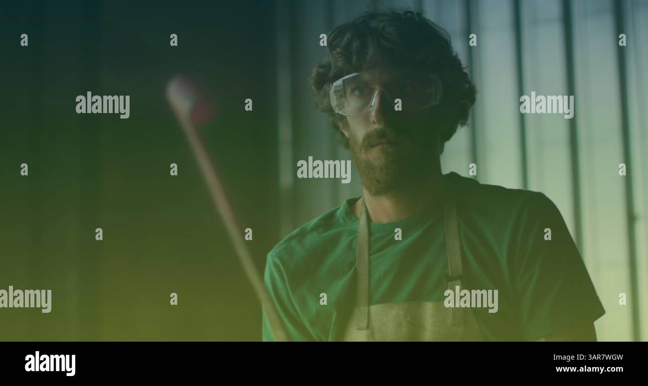 Immagine del lavoratore maschile caucasico con occhiali di sicurezza in officina Foto Stock