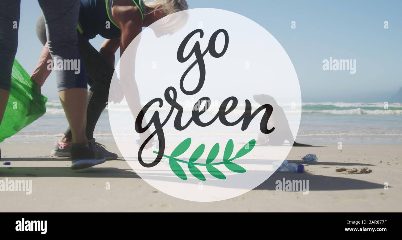 Immagine del testo Go green e del logo su due donne caucasiche che raccolgono rifiuti dalla spiaggia Foto Stock
