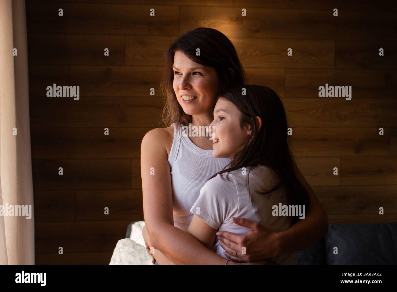 Amore generazionale. Mamma e figlia si abbracciano a vicenda. Le tradizioni familiari sono passate attraverso l'abbraccio. Eredità, genitorialità, concetto d'infanzia Foto Stock