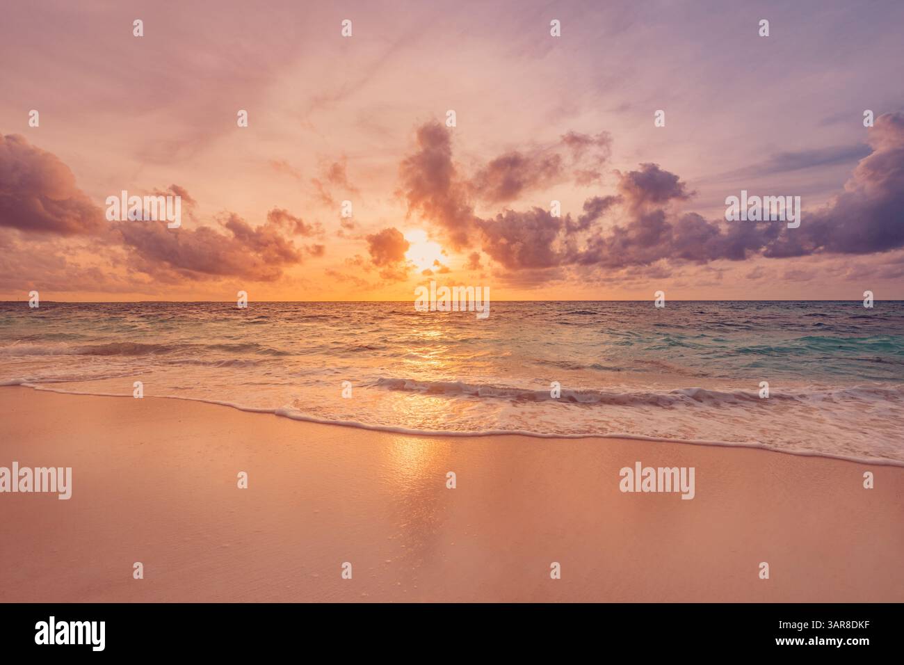 Viste ravvicinate sulla sabbia marina ispirano serenità in una perfetta scena isolana. Fantastico cielo, tramonto, sole, onde calme, splendido paesaggio da spiaggia. Bella natura Foto Stock