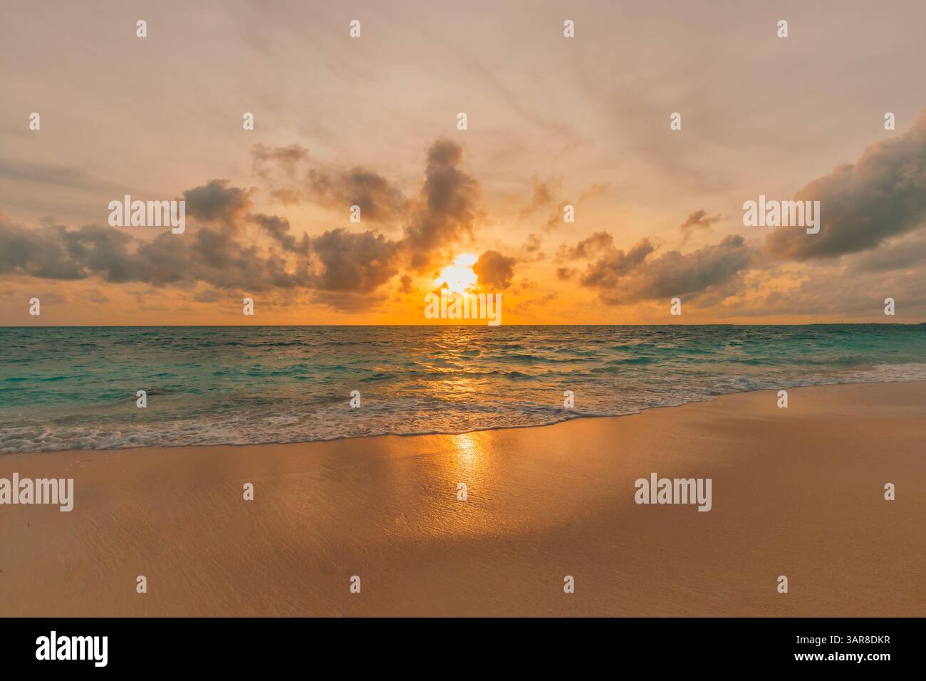 Viste ravvicinate sulla sabbia marina ispirano serenità in una perfetta scena isolana. Fantastico cielo, tramonto, sole, onde calme, splendido paesaggio da spiaggia. Bella natura Foto Stock