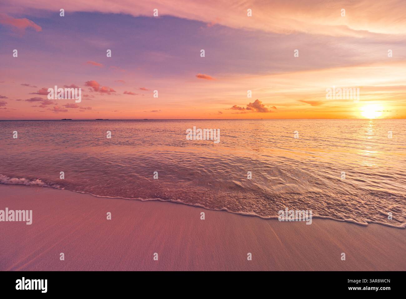 Colorato, tranquillo tramonto, spiaggia tropicale dell'isola, onde morbide, sabbia calda, luce dorata, splendida vacanza estiva a riva. Paesaggio naturale incredibile Foto Stock