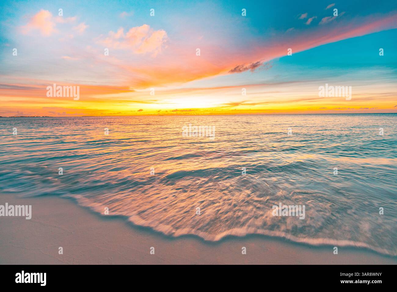 Colorato, tranquillo tramonto, spiaggia tropicale dell'isola, onde morbide, sabbia calda, luce dorata, splendida vacanza estiva a riva. Paesaggio naturale incredibile Foto Stock