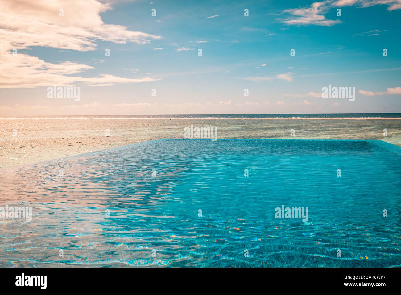 Piscina a sfioro astratta al tramonto con riflessi di luce estiva, perfetta per un design moderno e un'atmosfera di lusso che ispira la vista tropicale Foto Stock
