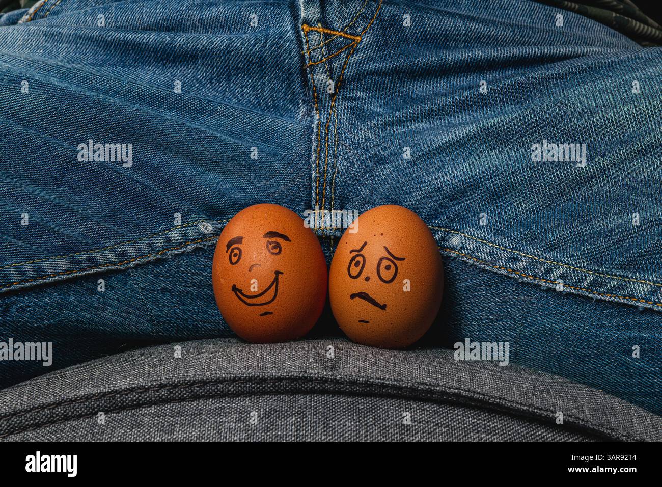 Due uova marroni con facce disegnate si appoggiano sulle ginocchia di una persona, creando un'atmosfera giocosa. Un uovo ha una faccia felice mentre l'altro sembra preoccupato, addin Foto Stock