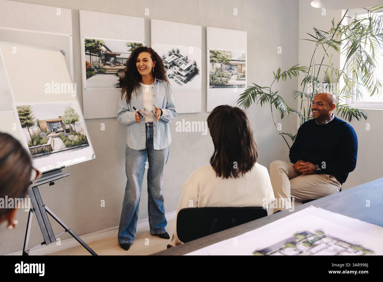 Un team collabora alla pianificazione strategica, utilizzando ausili visivi per migliorare le discussioni sui progetti in un ufficio. L'atmosfera riflette il professionalismo Foto Stock