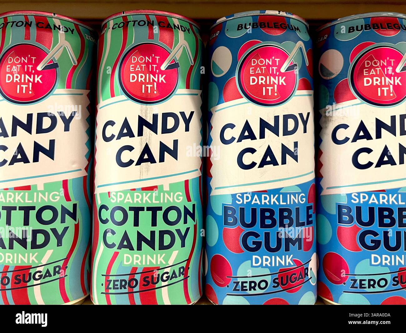 Le caramelle possono sprigionare le bollicine di gomma e le bevande senza zucchero al gusto di zucchero in scatola su uno scaffale del supermercato, offrendo un'opzione di rinfresco divertente e senza zucchero Foto Stock