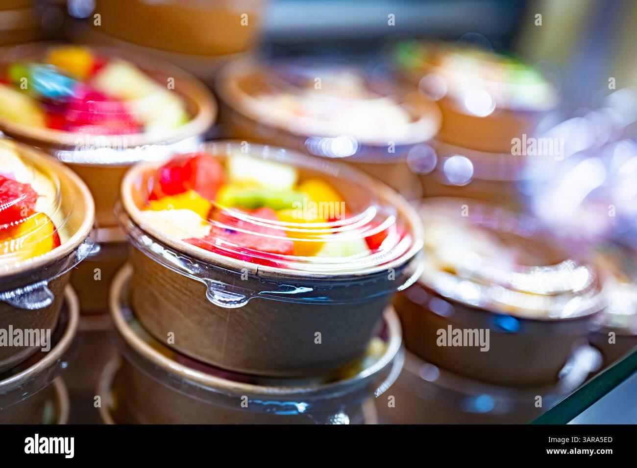 Macedonie di frutta preconfezionate esposte in un frigorifero commerciale Foto Stock