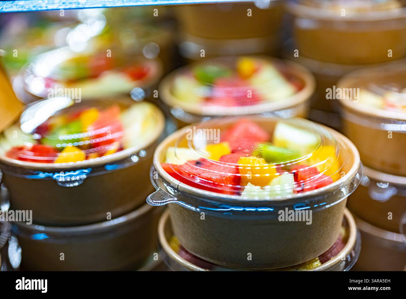 Macedonie di frutta preconfezionate esposte in un frigorifero commerciale Foto Stock