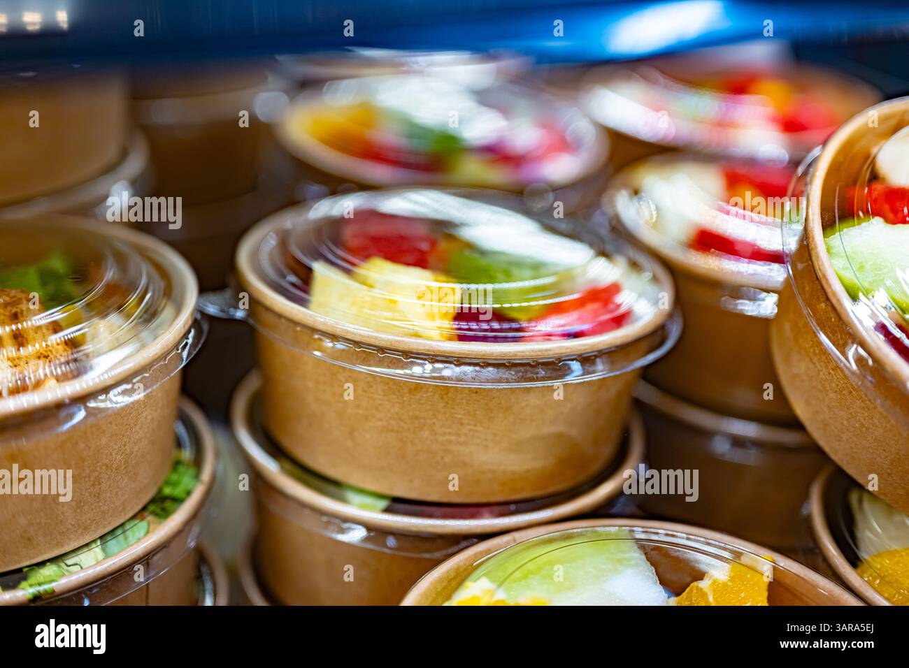 Macedonie di frutta preconfezionate esposte in un frigorifero commerciale Foto Stock