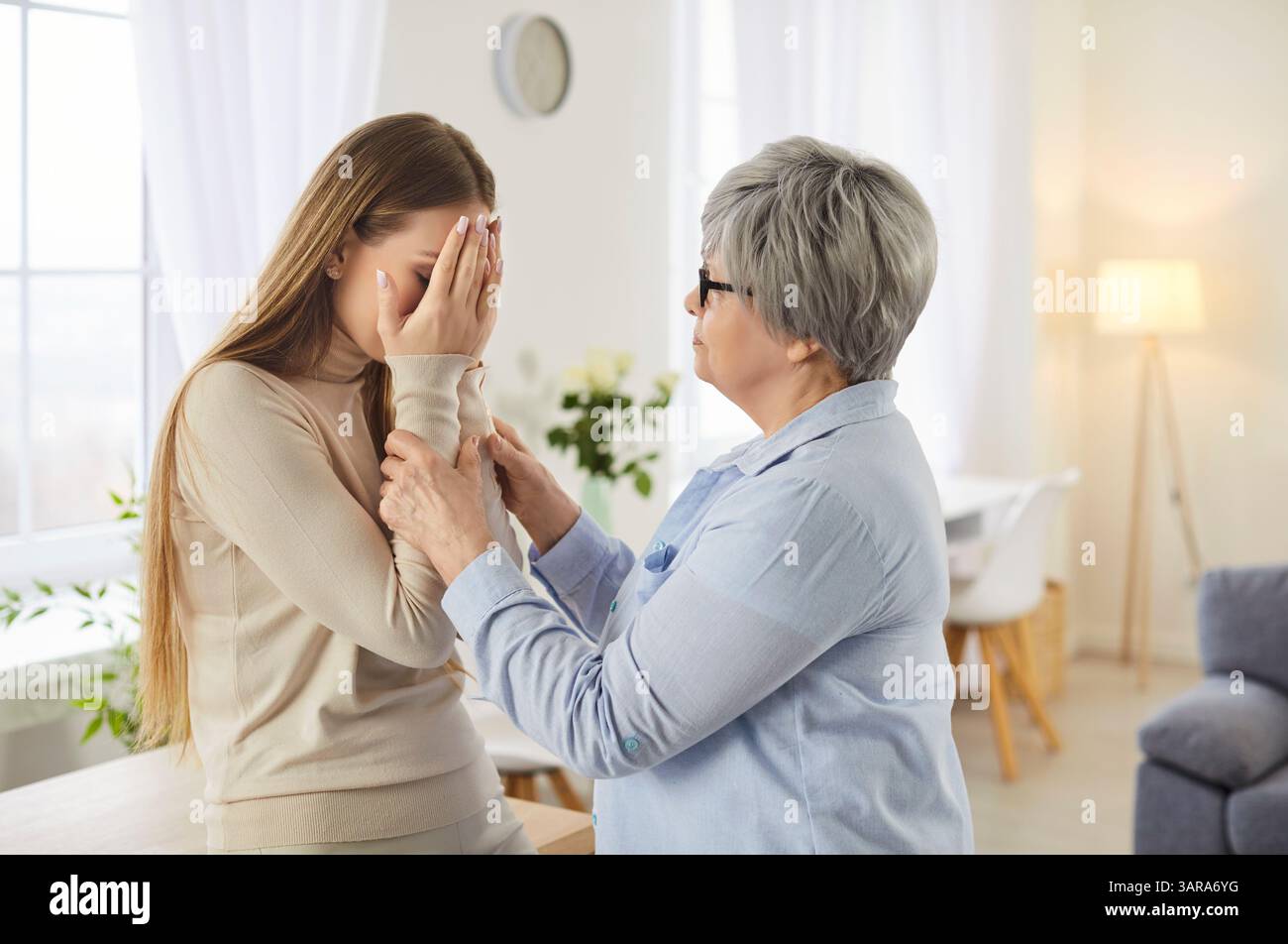 Donna anziana che calma la figlia adulta sconvolta che ha qualche problema Foto Stock