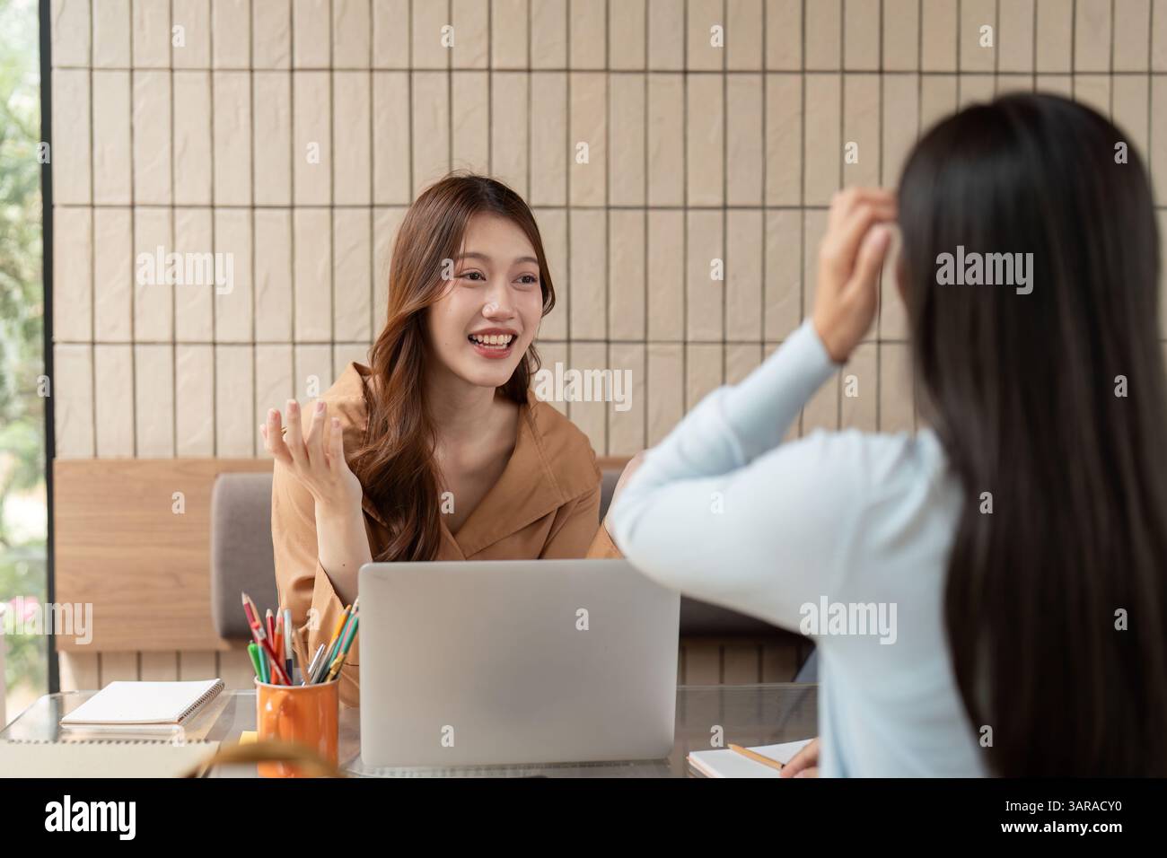 Sessione di studio e ambiente di apprendimento. Studenti impegnati in una discussione interattiva durante una sessione di studio in un bar moderno. Foto Stock
