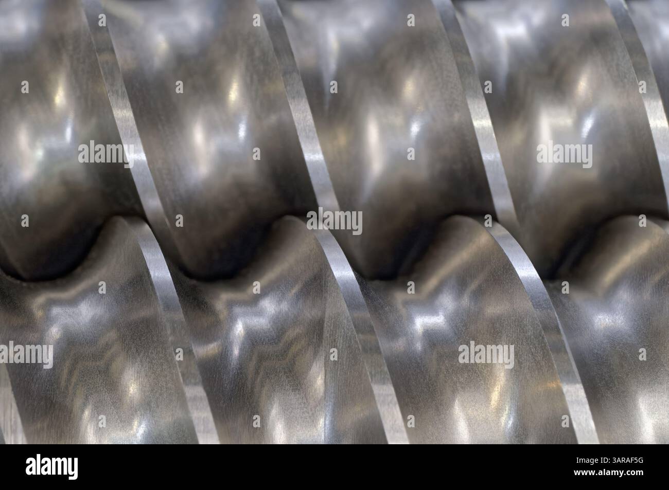 Pompa elicoidale in acciaio, compressore, primo piano del trasportatore, messa a fuoco selettiva, background industriale astratto in metallo Foto Stock