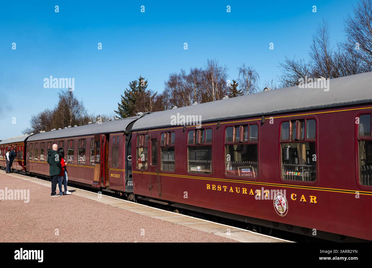 Persone che si imbarcano sulla ferrovia a vapore Strathspey, patrimonio del carbone, alla stazione ferroviaria di Aviemore, Highlands scozzesi, Scozia, Regno Unito Foto Stock