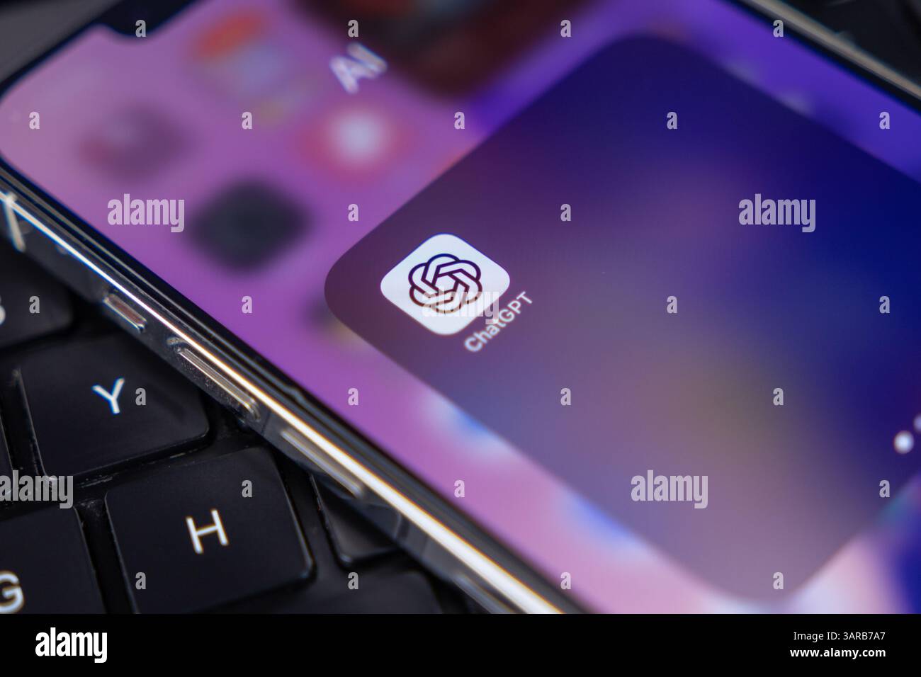 Poznan, Polonia – 14 aprile 2025: Icona mobile ChatGPT visualizzata sulla schermata iniziale dello smartphone appoggiata sulla tastiera del notebook, che rappresenta l'utilizzo moderno delle app ai in t Foto Stock