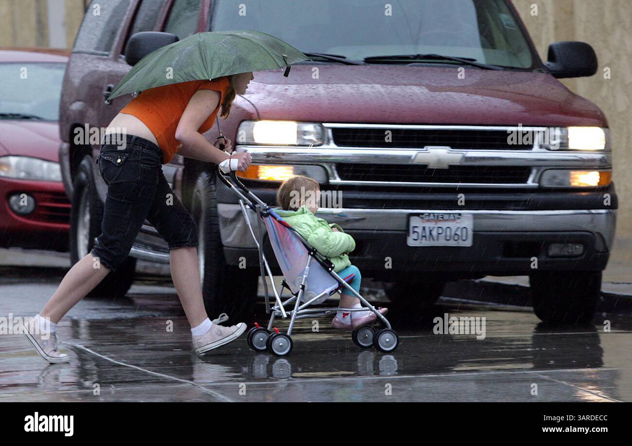 26 gennaio 2010 - Bakersfield, CA, USA - Casey Christie / The Californian. Una madre cerca di mantenere lei e suo figlio il più asciutti possibile, martedì, lungo Chester Avenue, mentre le piogge scendono a Bakersfield. (Immagine di credito: © The Bakersfield Californian/ZUMApress.com) Foto Stock