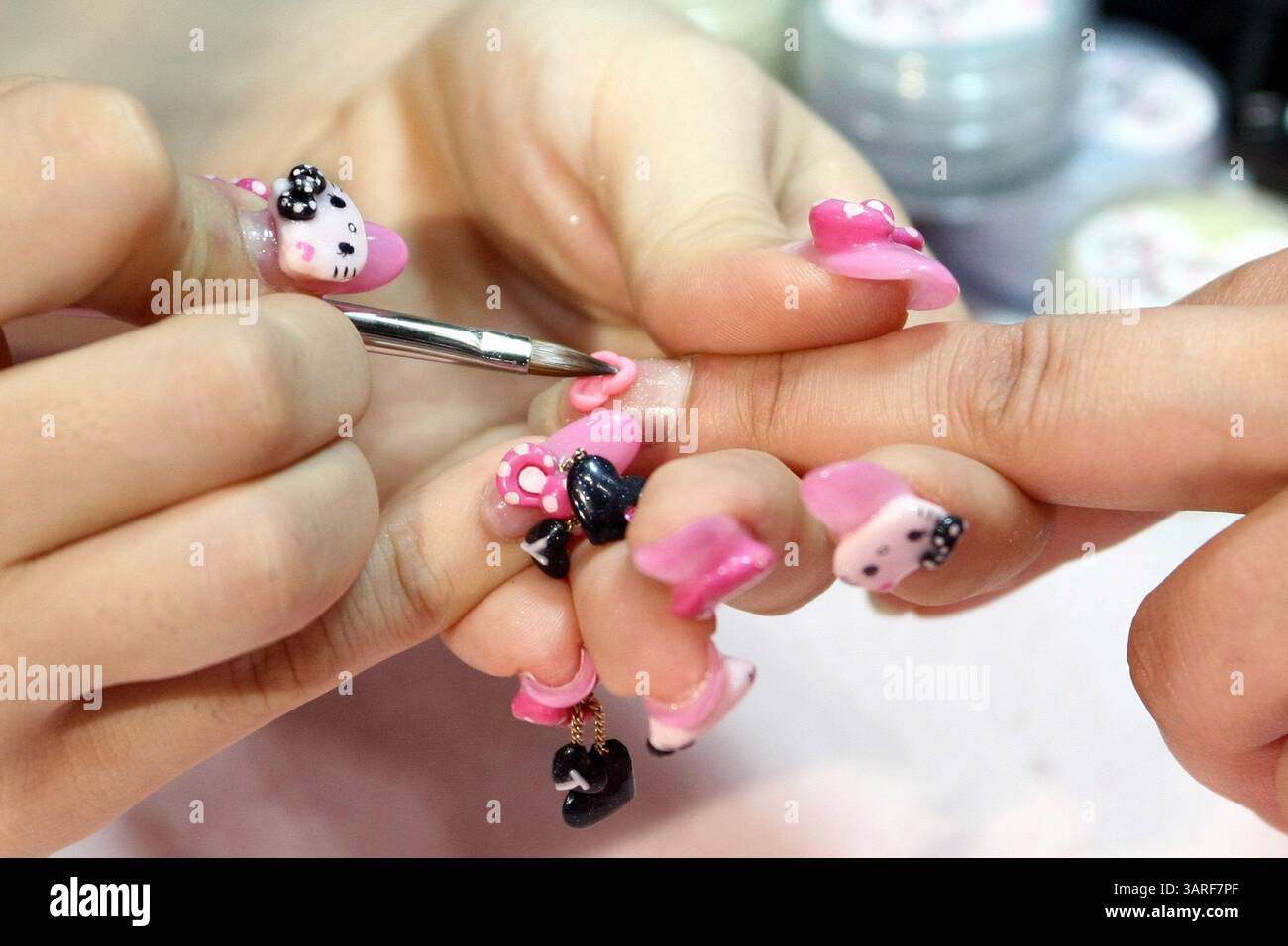 17 maggio 2010 - Tokyo, Giappone - Uno stilista di unghie applica pezzi decorativi in plastica Hello Kitty alle unghie durante il 13° Beautyworld Japan a Tokyo Big Sight, Giappone, il 17 maggio 2010. L'evento che si terrà dal 17 al 19 maggio presenta le ultime tecniche, i prodotti cosmetici per capelli, la cura e le unghie, le attrezzature di bellezza, i prodotti per il salone, i prodotti Spa & benessere, i servizi di profumeria e i trattamenti legati all'industria della bellezza, allo stile di vita ecologico e al LOHAS. Quasi 600 espositori provenienti da 23 paesi e regioni partecipano alla fiera annuale. (Immagine di credito: © Hitoshi Yamada/ZUMA Press) Foto Stock