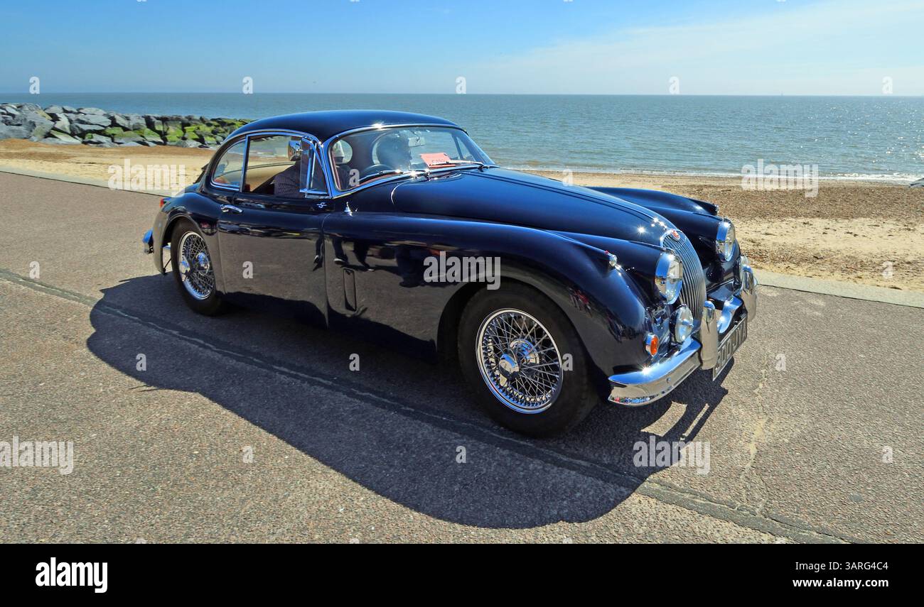 Classic Jaguar XK 150 3,8 Coupé parcheggiata sulla spiaggia e sul mare sullo sfondo Foto Stock