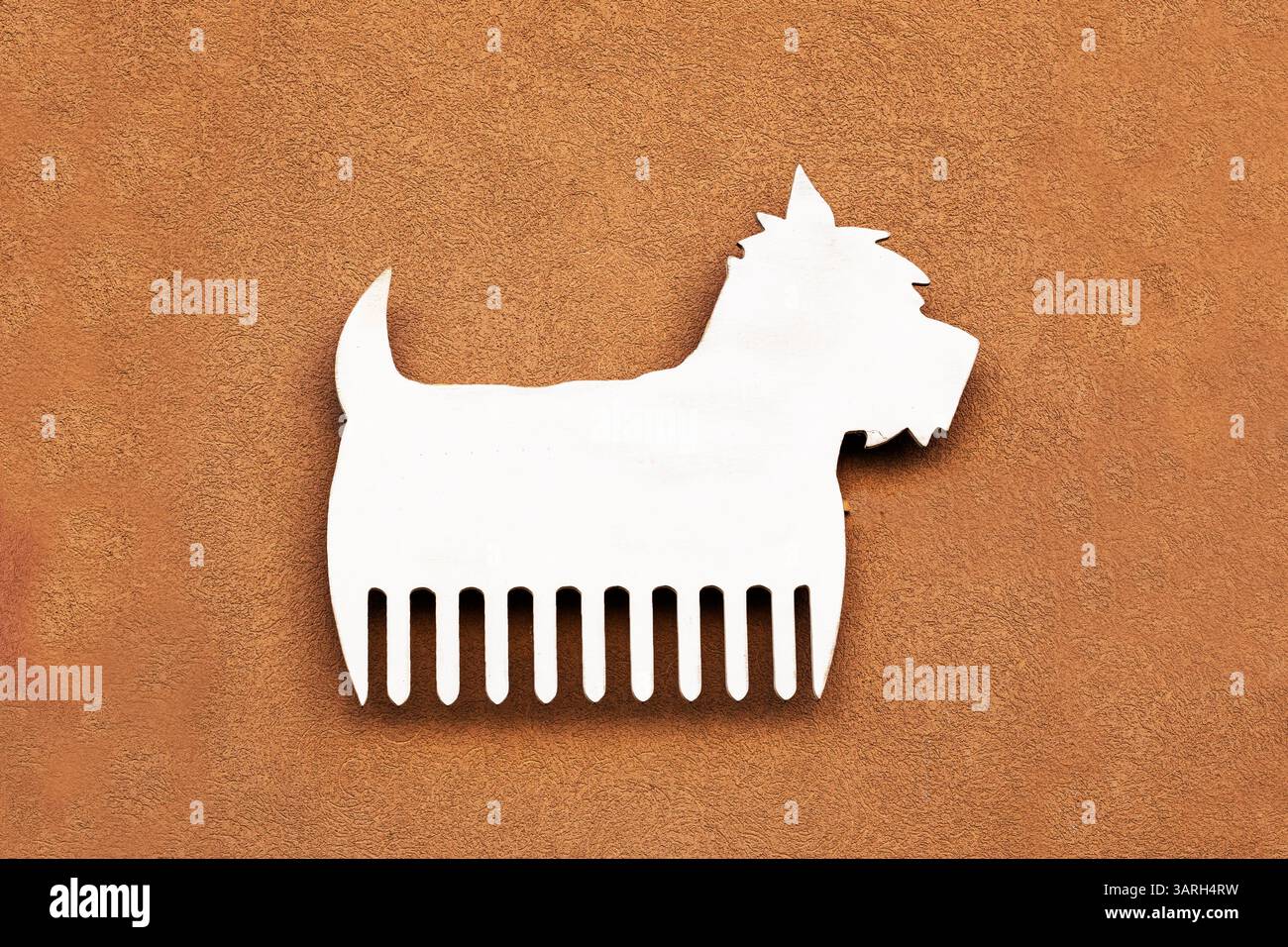 Graziosa silhouette bianca di un West Highland White Terrier con un pettine. tosatura dei cani Foto Stock