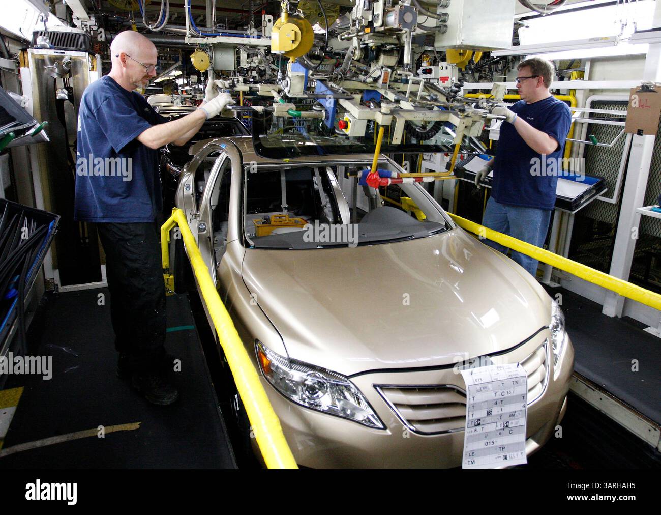 08 feb. 2010 - Georgetown, Kentucky, USA - i membri del team Jeff Lustenberg, a sinistra, e Bill Ingram, a destra, installarono un parabrezza su una nuova Camry mentre la produzione riprese oggi presso la linea di assemblaggio numero uno presso lo stabilimento Toyota Motor Manufacturing Kentucky, 1001 Cherry Blossom Way Georgetown, Ky., lunedì, febbraio, 08, 2010. la linea numero uno, che produce Camrys e Avalons, è stata chiusa la scorsa settimana, mentre la società ha indagato sui pedali del gas appiccicosi installati sui veicoli prodotti su quella linea. La seconda linea, che produce Camrys, Camry ibrids e Venzas, è rimasta attiva come veniva usata Foto Stock