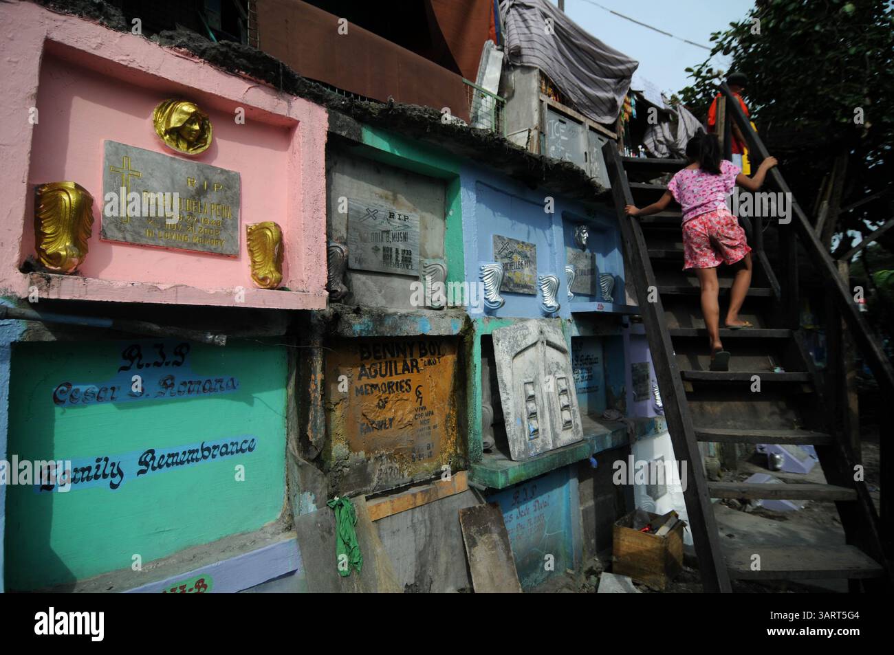31 ottobre 2013 - Manila, Filippine - Una ragazza usa una scala improvvisata per arrivare a casa sua in cima alle tombe del cimitero nord di Manila, Filippine, 31 ottobre 2013. I filippini celebrano ogni anno il giorno di Ognissanti affollando i cimiteri per visitare parenti e persone care in partenza. (Immagine di credito: © Ezra Acayan/ZUMAPRESS.com) Foto Stock