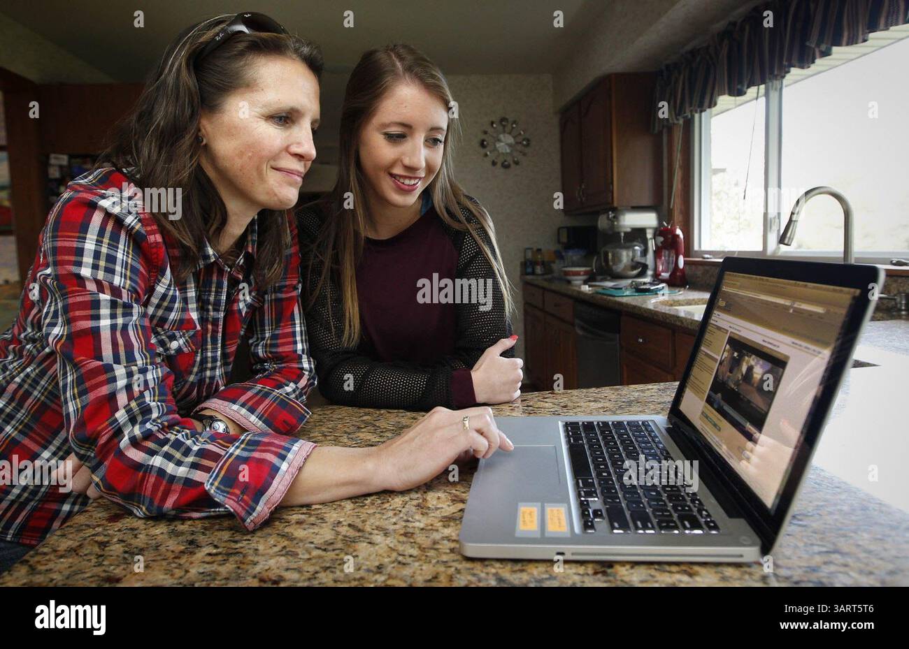 26 ottobre 2013 - Milwaukee, WISCONSIN, Stati Uniti - Virginie Olier, a sinistra, di Brookfield, Wisconsin, esamina i rapporti di guida con sua figlia Chloe, 16, 26 ottobre 2013. Ogni volta che Chloe entra in macchina e accende la chiave, una DriveCam nella sua auto controlla la guida, registra video e, quando commette errori, invia i rapporti ai computer dei genitori, dove possono esaminare i rapporti con lei. (Immagine di credito: © Gary Porter/MCT/ZUMAPRESS.com) Foto Stock