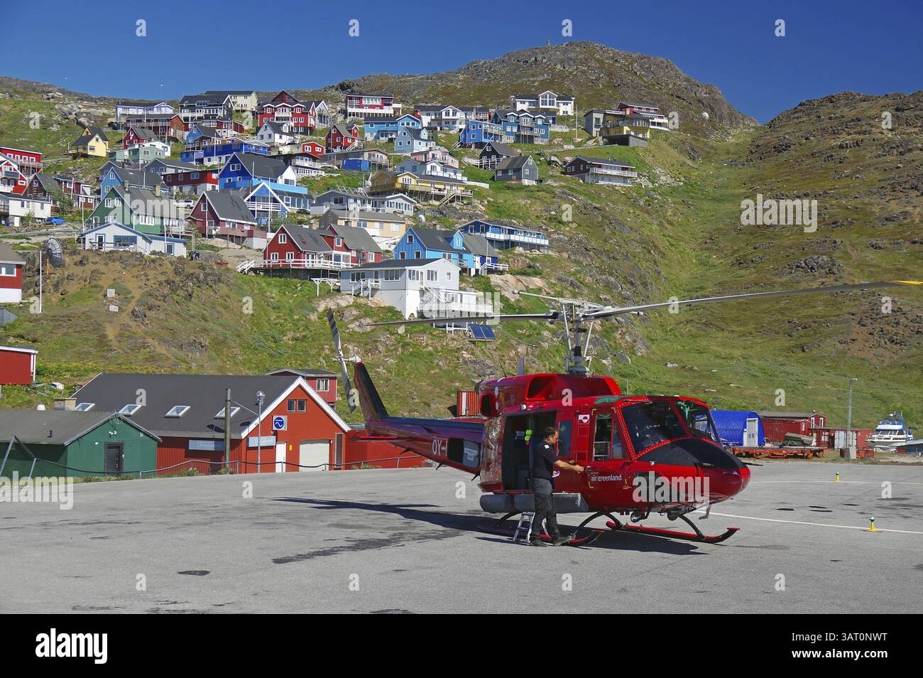 Elicottero su una piazza vicino a un insediamento con case colorate, Air Greenland, volo di linea, Chiesa del nostro Salvatore, Qaqortoq, Kujalleq, Groenlandia Foto Stock