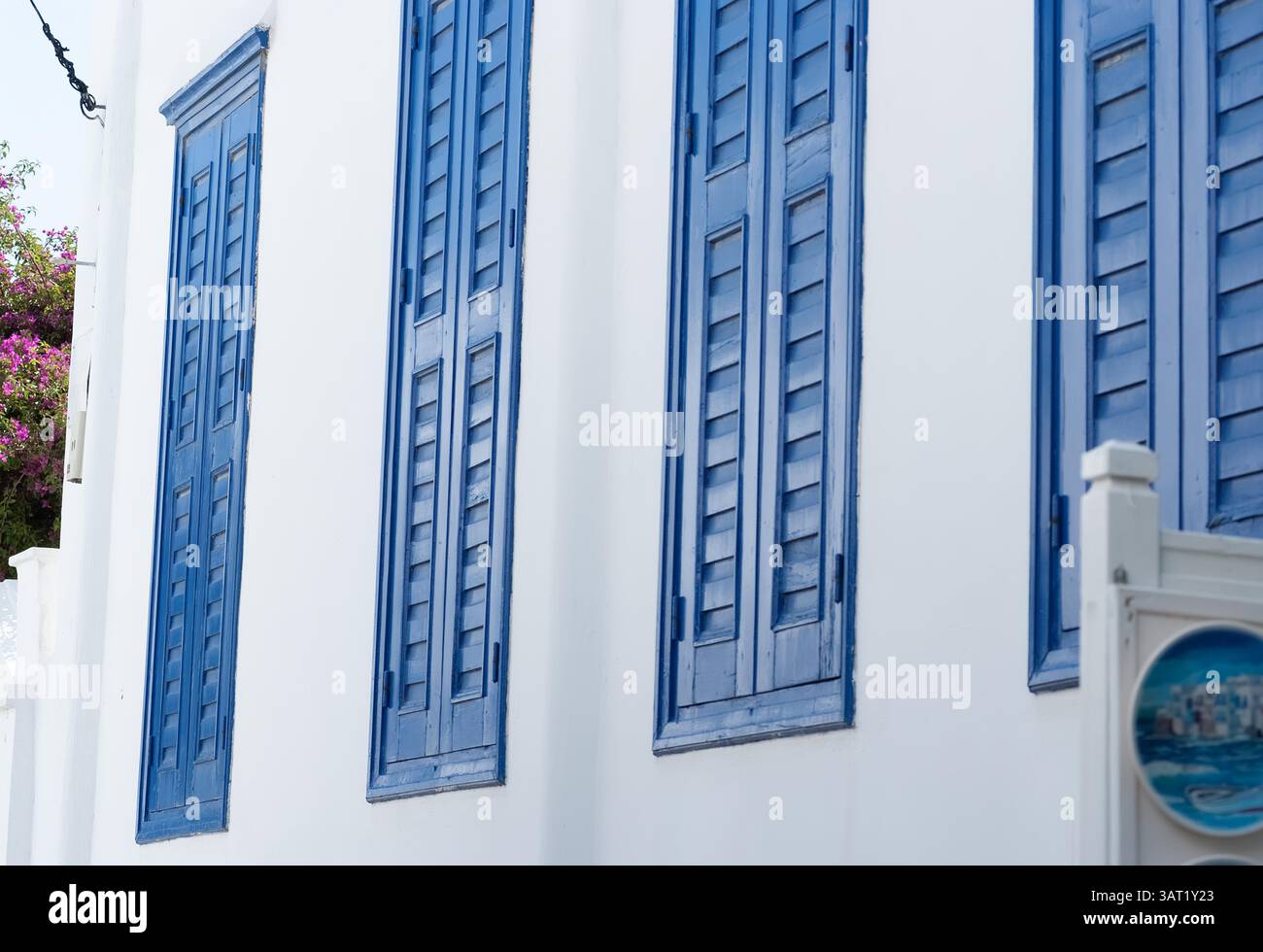 Persiane di legno blu in un edificio greco bianco, che mostra l'architettura delle Cicladi con audaci contrasto di colore e tradizionale stile isolano in un classico Ae Foto Stock