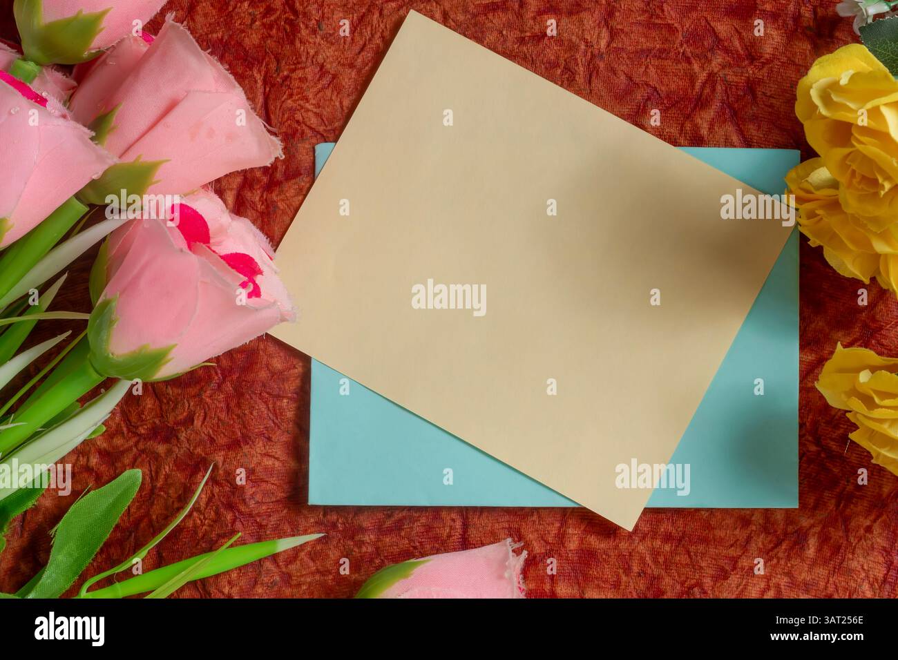 Un biglietto bianco con vivaci fiori decorativi su un tessuto colorato. Ideale per i biglietti d'auguri e i temi di festa. Foto Stock