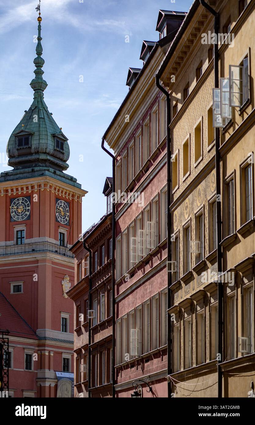 Una pittoresca vista sulla strada con edifici storici con facciate colorate e una torre dell'orologio sullo sfondo. Il cielo è limpido, aggiungendo al carattere Foto Stock