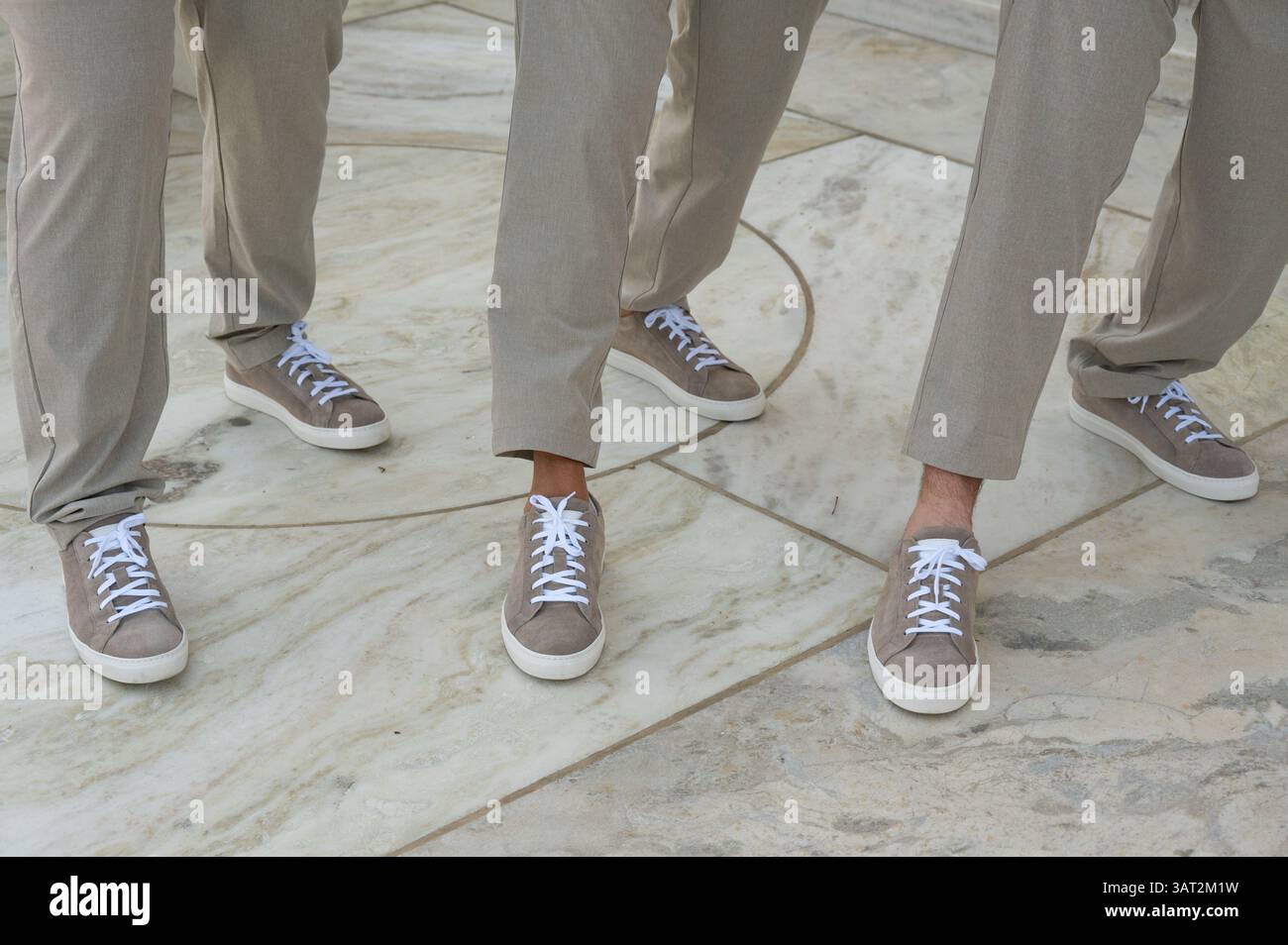 I guardiani indossano sneakers in pelle scamosciata abbinate e pantaloni Tan su Stone Floo Foto Stock