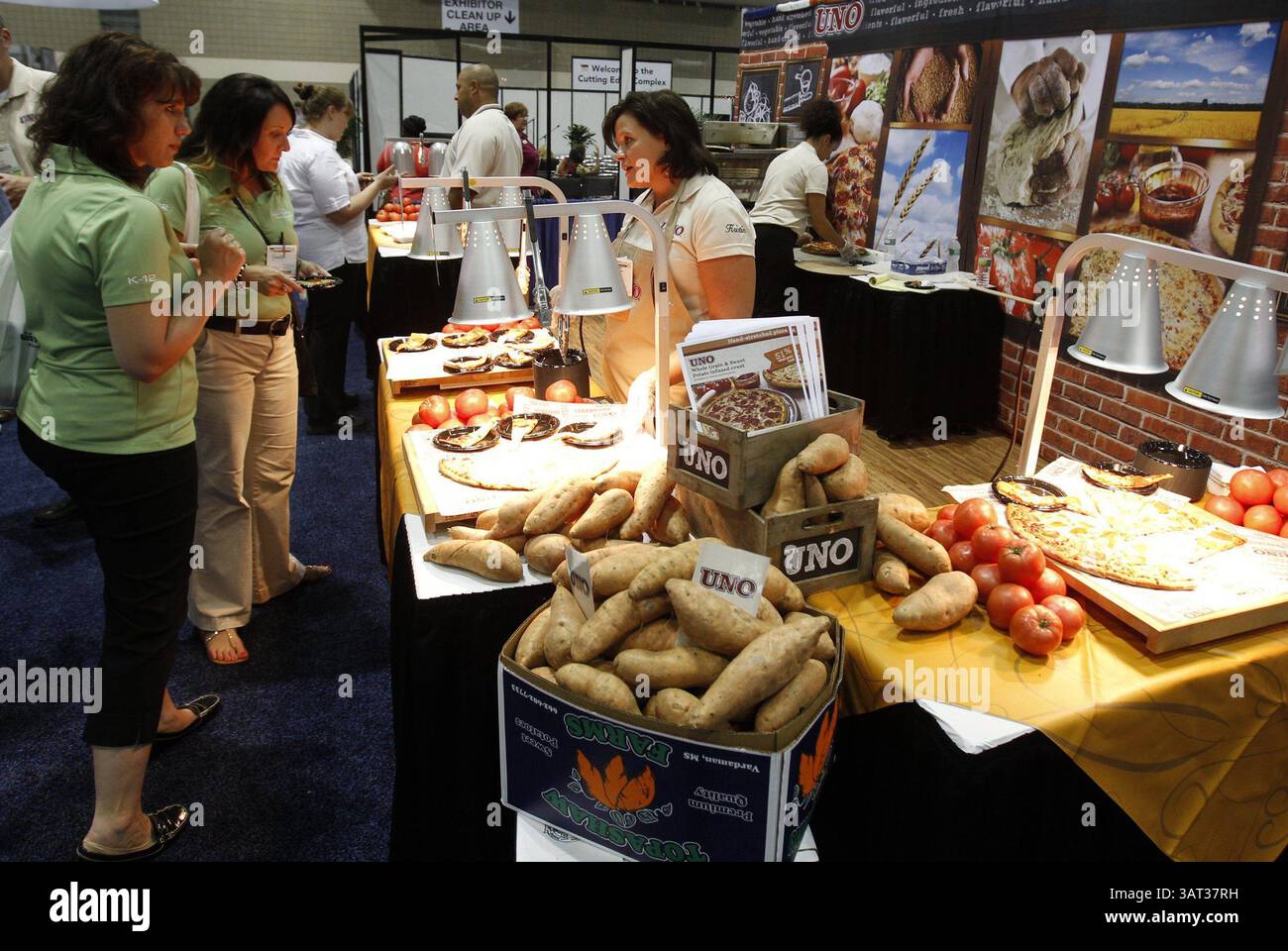 15 luglio 2013 - Kansas City, MO, USA - la pizza con crosta infuso di patate dolci è stata servita presso lo stand uno Foods, 15 luglio 2013, alla convention nazionale della School Nutrition Association a Bartle Hall a Kansas City, Missouri. Kristin Kopke (a destra) ha spiegato il valore nutrizionale della pizza. (Immagine di credito: © Keith Myers/MCT/ZUMAPRESS.com) Foto Stock