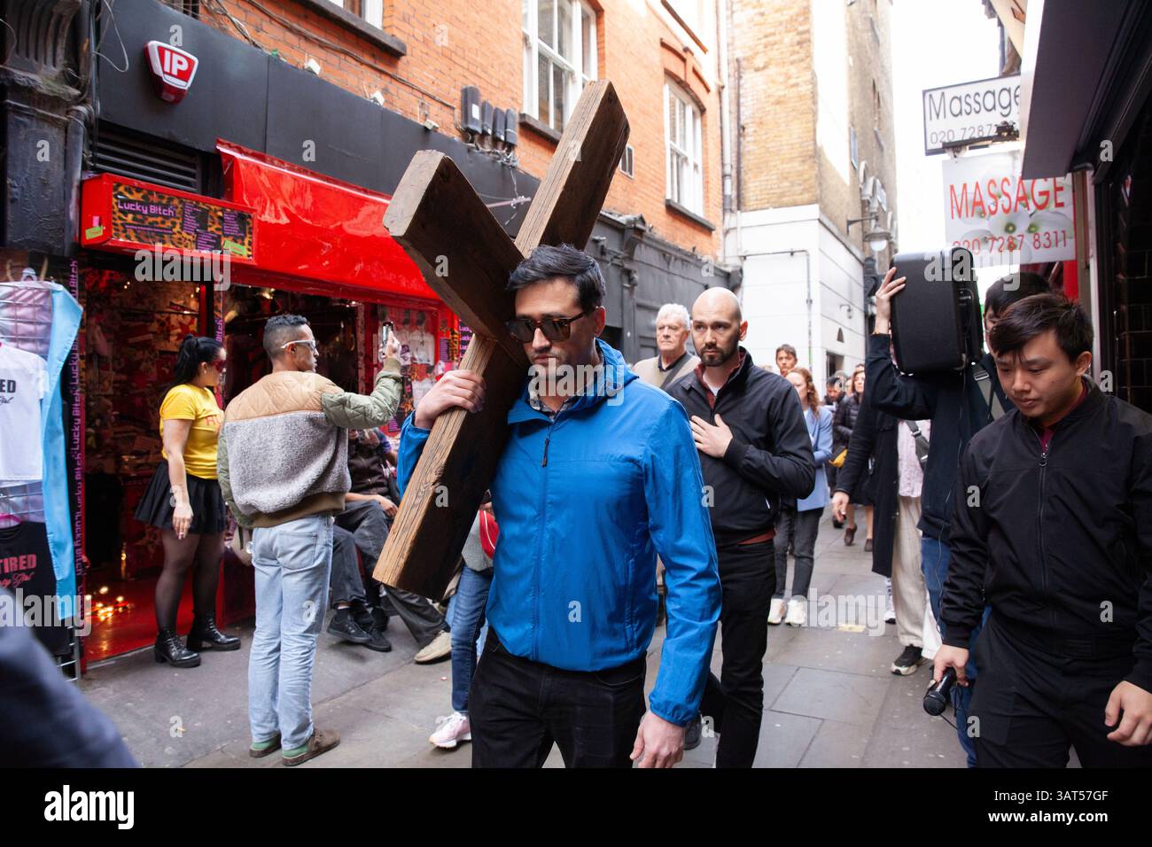 Londra, Regno Unito. 18 aprile 2025. In occasione del venerdì Santo, la Chiesa cattolica di San Patrizio ha tenuto una processione per segnare le stazioni della Croce, portando un crocifisso in legno intorno alle vicine strade di Soho. Il parroco padre Alexander Sherbrooke guidò la congregazione multiculturale in preghiere per segnare ciascuno dei passi del cammino di Gesù, e i fedeli cantarono mentre camminavano. Crediti: Anna Watson/Alamy Live News Foto Stock