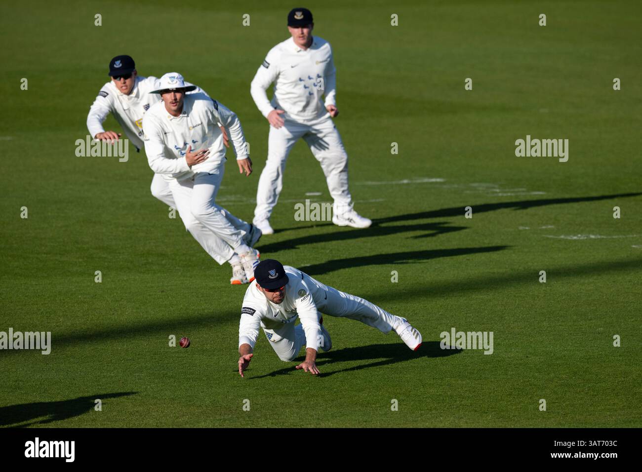 Sussex contro Somerset - Rothesay County Championship HOVE, INGHILTERRA - 11 APRILE: Sussex Slip fielder Tom Haines che si tuffa per catturare la palla osservata dai compagni di squadra Foto Stock