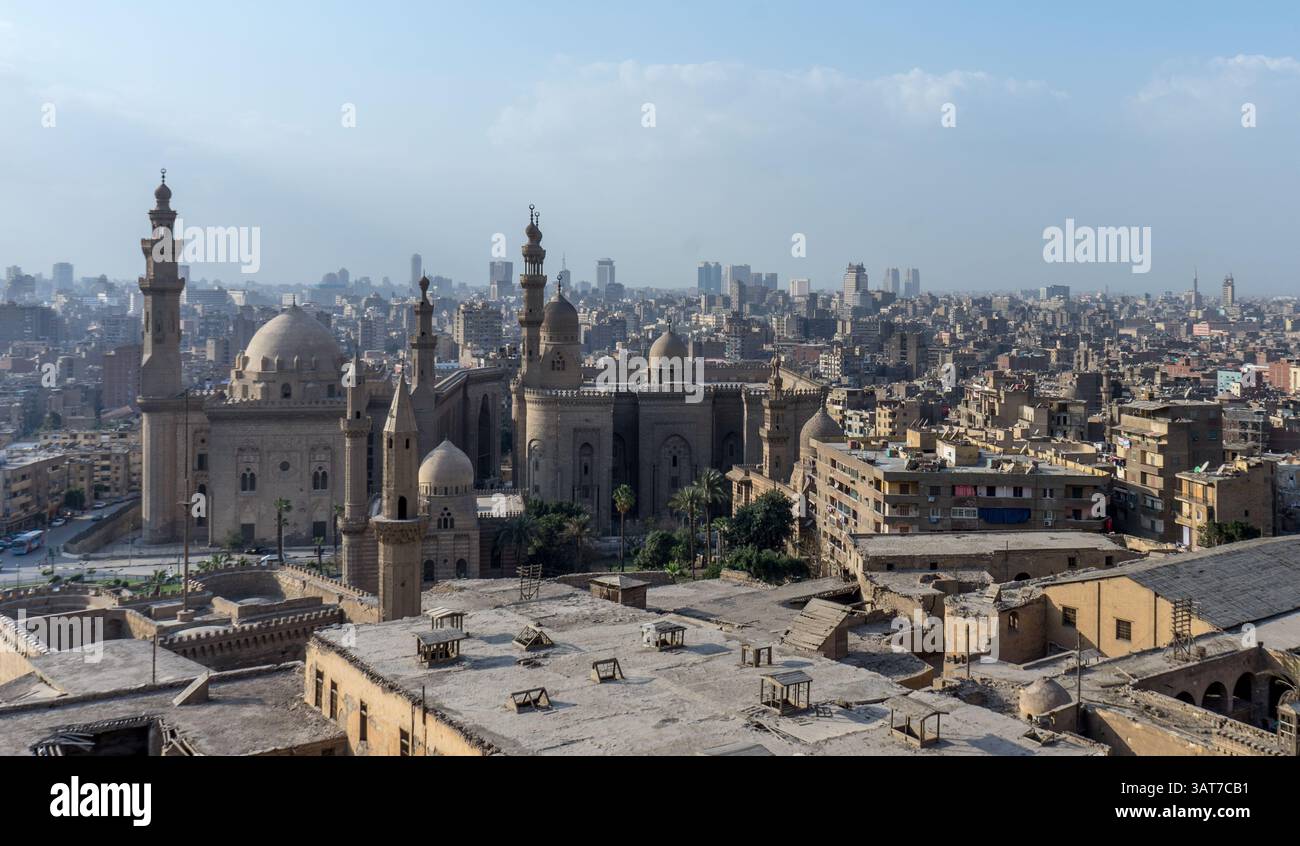 Una vista panoramica del Cairo, in Egitto, con moschee storiche ed edifici moderni sotto un cielo azzurro. La scena cattura la miscela di archi antichi Foto Stock
