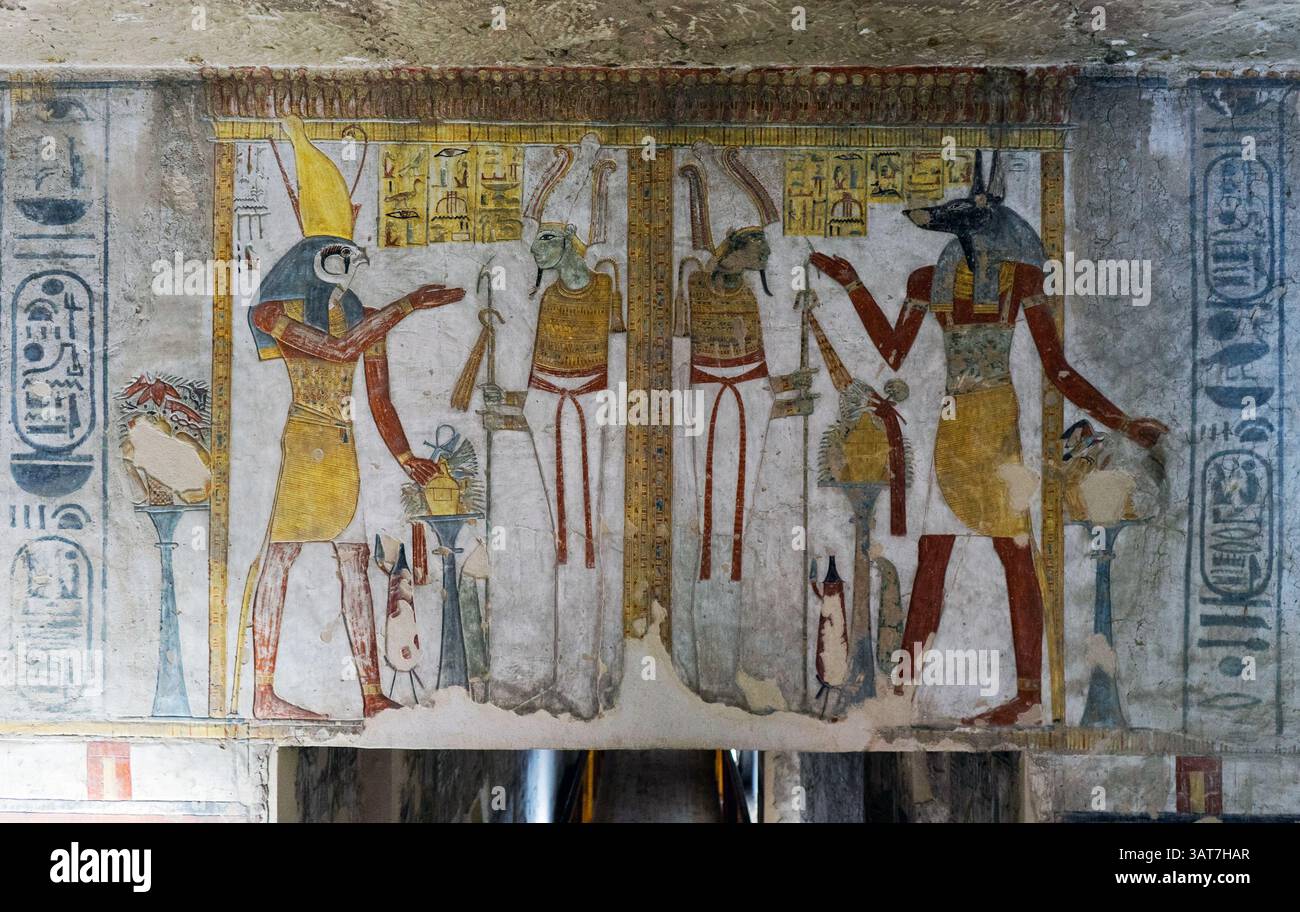 Antico dipinto murale egizio raffigurante dei e faraoni in un ambiente funerario, che mostra geroglifici e colori vivaci. Foto Stock