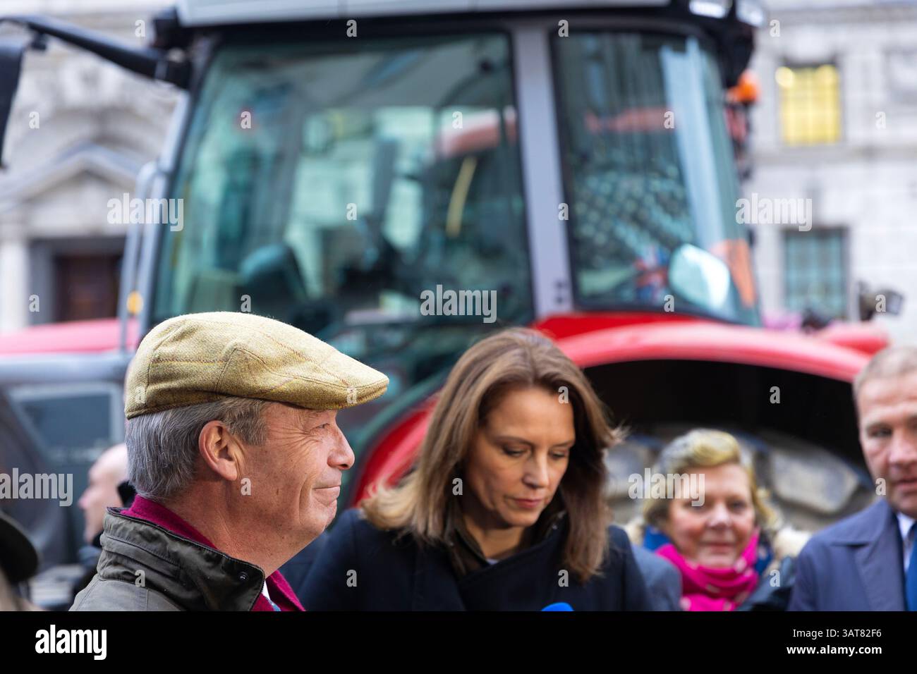 Nigel Farage, leader del Reform UK, parla ai media mentre i trattori scendono a Westminster a Londra per protestare contro le modifiche alla tassa di successione. Foto Stock