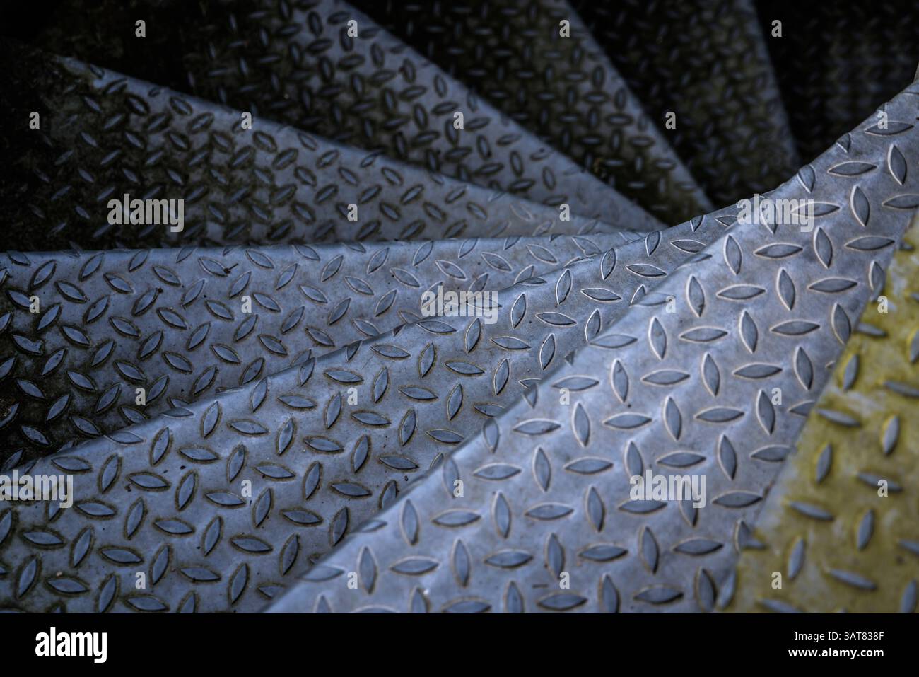 I gradini della vecchia scala a spirale in metallo scompaiono nel buio Foto Stock