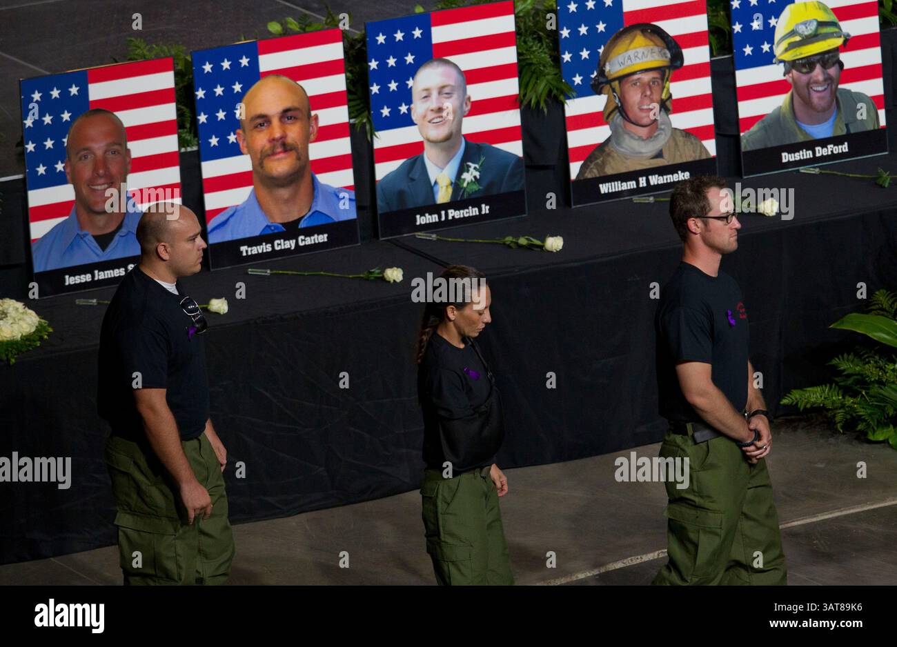 9 luglio 2013 - Prescott Valley, Arizona, Stati Uniti - ex vigili del fuoco Granite Mountain Hotshot camminano davanti alle foto dei loro compagni caduti durante un servizio commemorativo al Tim's Toyota Center a Prescott Valley, Ariz. 19 membri dell'equipaggio Granite Mountain Hotshot morirono combattendo l'incendio di Yarnell Hills, a circa 40 miglia a sud-ovest di Prescott, Ariz., giugno 30. (Immagine di credito: © Michael Chow-POOL/The Arizona Republic/ZUMAPRESS.com) Foto Stock