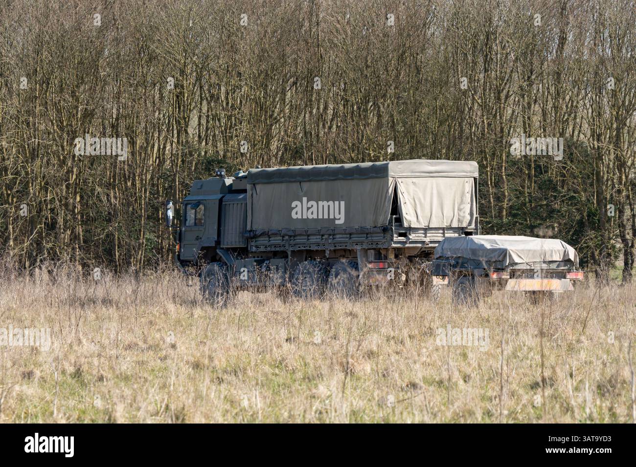 Camion multiuso MAN HX 6x6 dell'esercito britannico con rimorchio in movimento lungo una pista sterrata in campagna Foto Stock