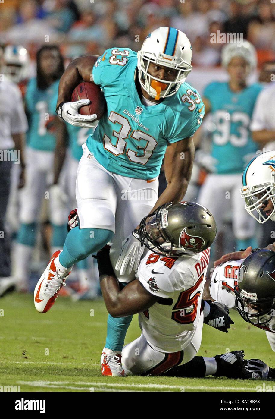24 agosto 2013 - Miami, FL, USA - Daniel Thomas dei Miami Dolphins trascina Lavonte David dei Tampa Bay Buccaneers nel primo quarto al Sun Life Stadium di Miami, Florida, sabato 24 agosto 2013. I Buccaneers sconfissero i Dolphins, 17-16. (Immagine di credito: © Charles Trainor Jr/MCT/ZUMAPRESS.com) Foto Stock