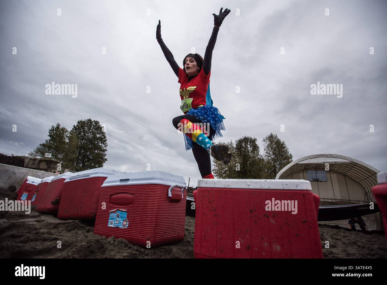 29 settembre 2013 - Vancouver, British Columbia, Canada - Una donna vestita da supereroina salta su un campo fresco presso il secondo campo Beach Dash durante la prima sfida annuale di ostacoli urbani di concrete Hero a Vancouver, British Columbia, domenica 29 settembre 2013. Concrete Hero è una gara e una sfida urbana a tempo di 9K che incorpora un mix di punti di riferimento di â?BC-Themedâ?Â, a beneficio della BC Cancer Foundation. Carmine Marinelli/Vancouver 24hours/QMI Agency (immagine di credito: © Carmine Marinelli/QMI Agency/ZUMAPRESS.com) Foto Stock