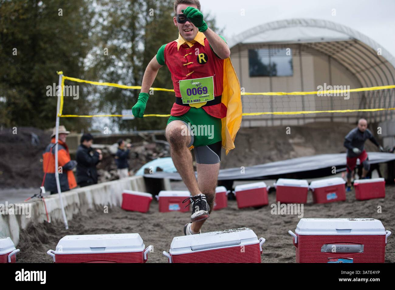 29 settembre 2013 - Vancouver, British Columbia, Canada - Un uomo vestito da supereroe Robin salta su un campo fresco al secondo campo Beach Dash durante la prima sfida annuale di ostacoli urbani di concrete Hero a Vancouver, British Columbia, domenica 29 settembre 2013. Concrete Hero è una gara e una sfida urbana a tempo di 9K che incorpora un mix di punti di riferimento di â?BC-Themedâ?Â, a beneficio della BC Cancer Foundation. Carmine Marinelli/Vancouver 24hours/QMI Agency (immagine di credito: © Carmine Marinelli/QMI Agency/ZUMAPRESS.com) Foto Stock
