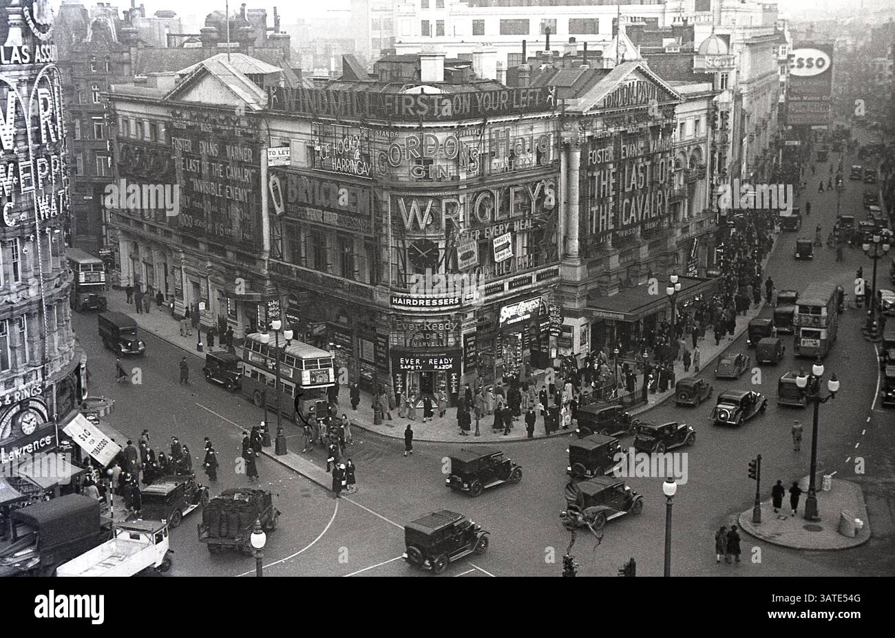 1938, vista aerea storica su Piccadilly Circus, nel centro di Londra, che mostra gli autobus e le automobili dell'epoca e i cartelloni pubblicitari. Film, The Last Cavalry (conosciuta anche come Army Girl) in proiezione al London Pavilion. Foto Stock