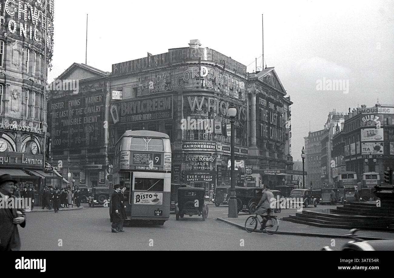 1938, storico, Piccadilly Circus nel centro di Londra, che mostra l'autobus e le automobili routemaster numero 9 dell'epoca e i cartelloni pubblicitari. Film, The Last Cavalry (conosciuta anche come Army Girl) in proiezione al London Pavilion. Foto Stock