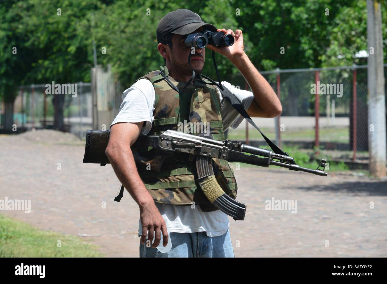 25 agosto 2013 - Santa Ana Amatlan, Michoacan, Messico - Un membro del gruppo di autodifesa controlla il traffico attraverso il binocolo nella città di Santa Ana Amatlan. (Immagine di credito: © Miguel Juarez Lugo/ZUMAPRESS.com) Foto Stock