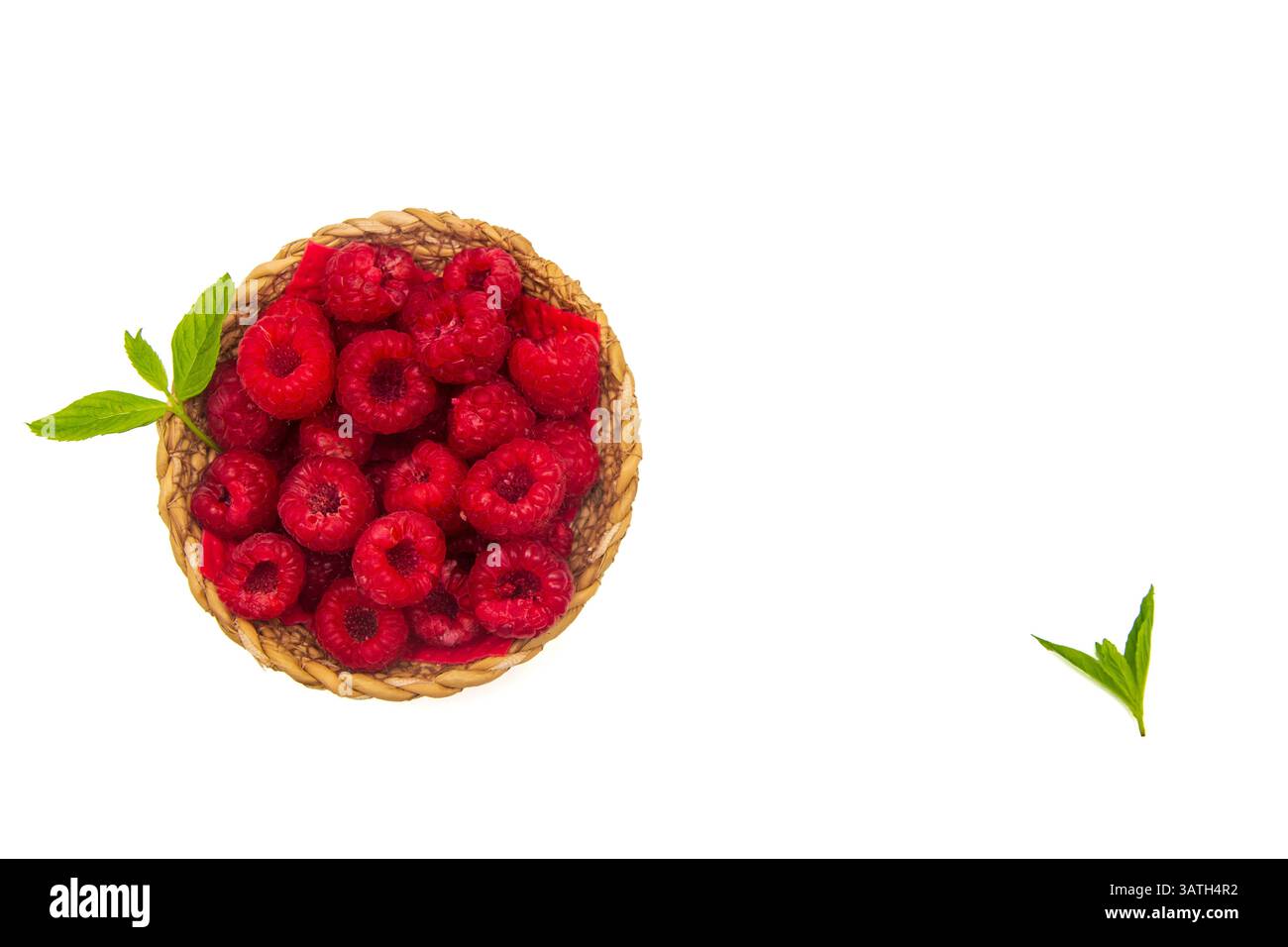 Lamponi in ciotola di vimini con foglia verde su sfondo bianco isolato Foto Stock