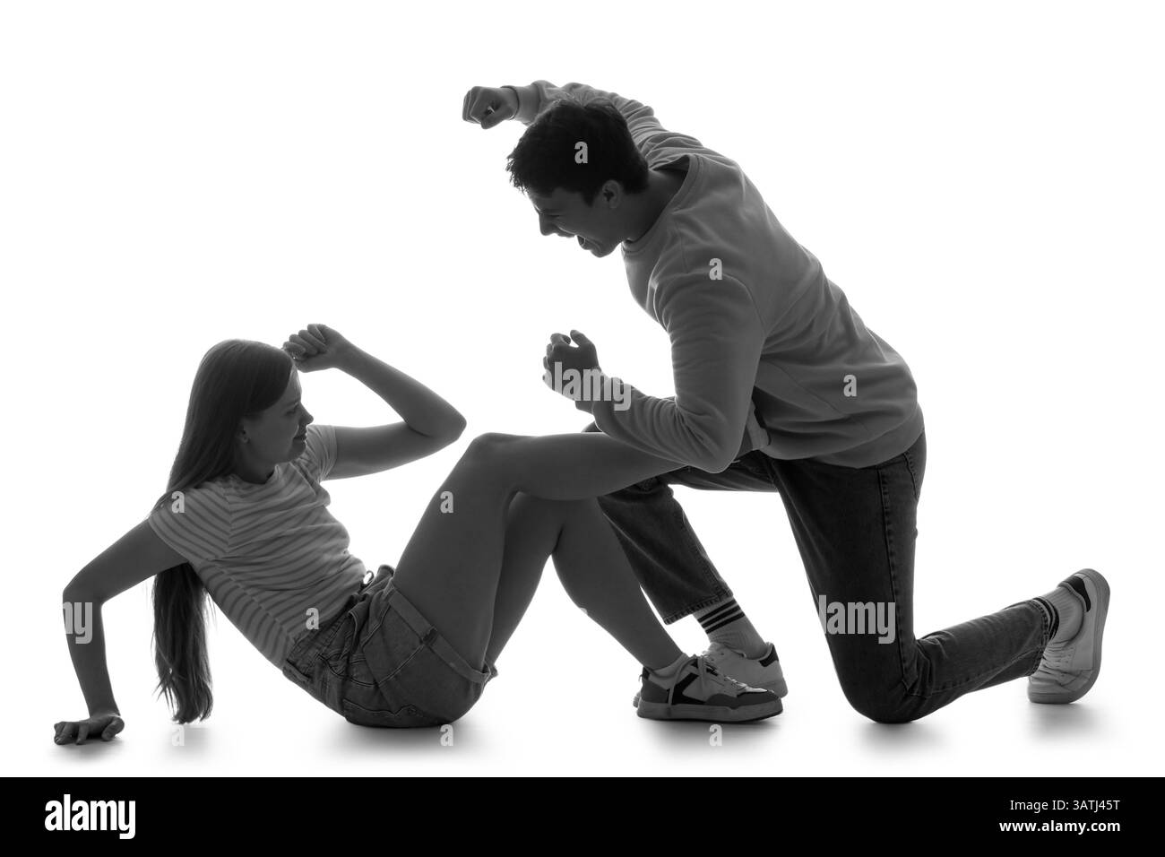 Silhouette di un uomo che picchia sua moglie su sfondo bianco. Concetto di violenza domestica Foto Stock