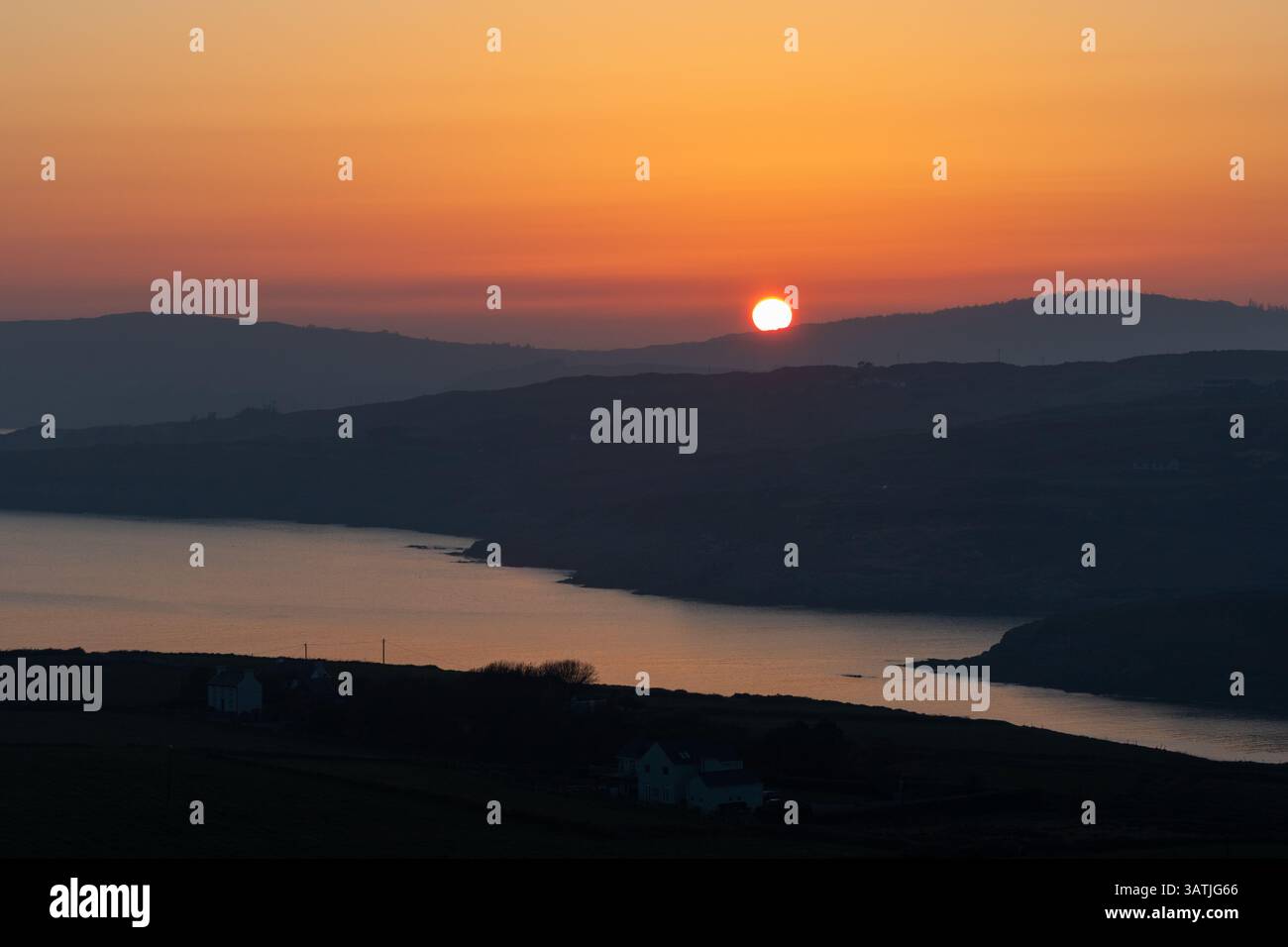 Il sole tramonta su colline lontane a West Cork, Irlanda Foto Stock